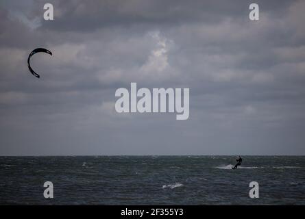 A windsurfer taking advantage of strong winds out on the water in Littlehampton, West Sussex Stock Photo