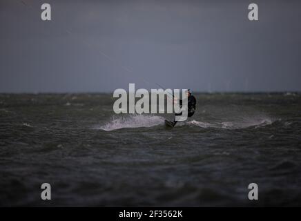 A windsurfer taking advantage of strong winds out on the water in Littlehampton, West Sussex Stock Photo