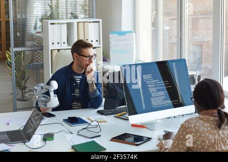 Portrait of modern IT developers using computers for code programming while working on VR software in office, copy space Stock Photo