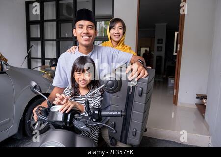 asian muslim family riding motorbike scooter together traveling with kid Stock Photo