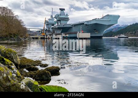 Finnart, Scotland, UK. 15 March 2021. Royal Navy aircraft carrier HMS Queen Elizabeth berthed on Long Loch  at Glenmallan to take on supplies and munitions ahead of naval exercises part of UK Carrier Strike Group 2021.  Iain Masterton/Alamy Live News Stock Photo