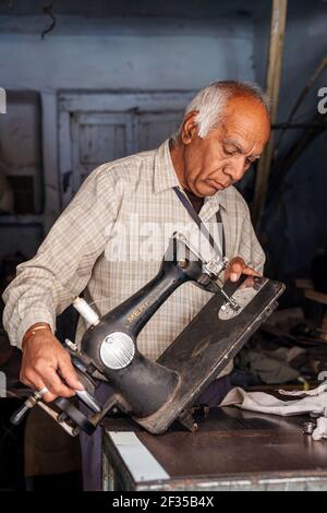 Portrait of elderly man repairing an old sewing machine, Jodhpur, Rajasthan, India Stock Photo