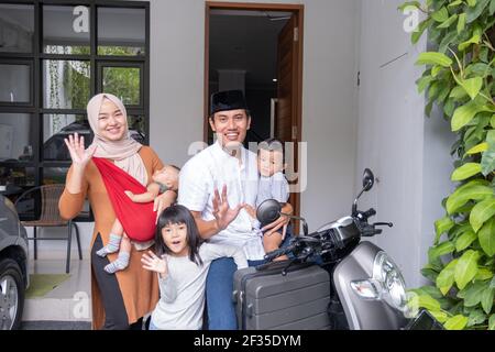 asian muslim family riding motorbike scooter together traveling with kid Stock Photo