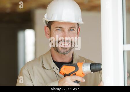 smiling man is fixing a window Stock Photo
