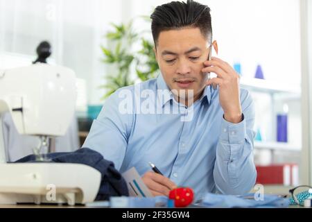 dressmaking design service worker talking phone Stock Photo