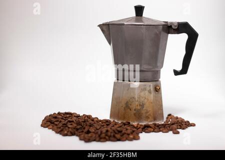 geyser coffee maker or moka pot isolated on white background with coffee beans nearby. Stock Photo