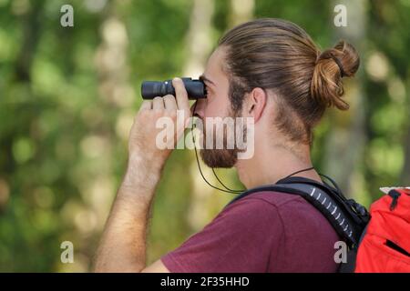 man with binoculars in the forest Stock Photo