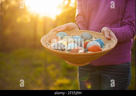 Girl holding a wooden plate with easter eggs Stock Photo