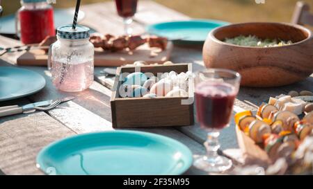 Served festive wooden table with dishes and food in the garden Stock Photo