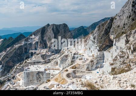 Carrara marble quarry site, net of dust road among huge stone blocks. Construction and mining raw material concept. Stock Photo