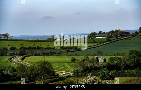 A countryside view of a winding road through green fields in a typical English scene Stock Photo