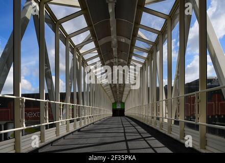 A view through a metal and glass bridge walkway Stock Photo