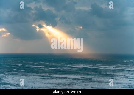 golden rays of the sun breaking through the storm clouds Stock Photo
