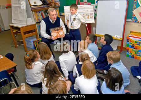 Male teacher leads Group reading at K-8 elementary education at St Marys Catholic Elementary school in St Clair Michigan MI Stock Photo