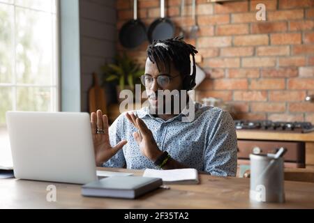 Black man expert in headphones assist client online using laptop Stock Photo