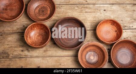 Handmade empty ceramic dishes and plates on wooden background. Collections of various bowls, traditional folk ornament, rustic style, vintage table. P Stock Photo
