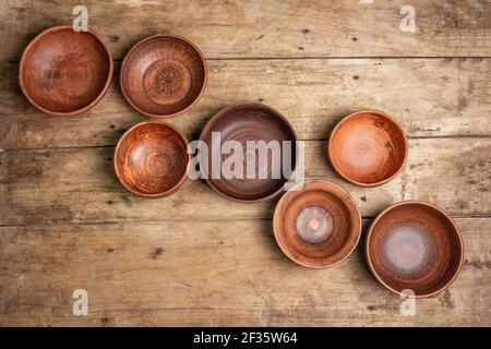 Handmade empty ceramic dishes and plates on wooden background. Collections of various bowls, traditional folk ornament, rustic style, vintage table. P Stock Photo