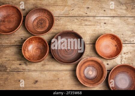 Handmade empty ceramic dishes and plates on wooden background. Collections of various bowls, traditional folk ornament, rustic style, vintage table. P Stock Photo