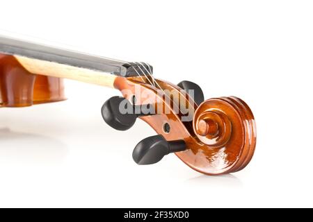 Close up macro of scroll on brown wooden fiddle or violin, classic musical instrument, over white background, selective focus Stock Photo