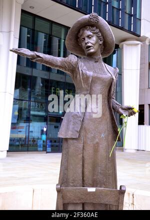 The statue of Emmeline Pankhurst in St Peter's Square, Manchester, England, United Kingdom, holds a flower left after the vigil in the memory of Sarah Everard on 13th March, 2021. A London Metropolitan police officer was charged with Sarah Everard's kidnapping and murder on 12th March. He appeared at Westminster Magistrates' Court on 13th March and was remanded in custody to appear at the Old Bailey on 16th March. Emmeline Pankhurst was the leader of the suffragette movement in the United Kingdom. The bronze statue was sculpted by Hazel Reeves. Stock Photo