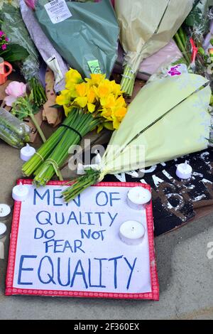 Placards which lobby for women's safety and flowers at the statue of Emmeline Pankhurst in St Peter's Square, Manchester, England, United Kingdom, left after the vigil in the memory of Sarah Everard on 13th March, 2021. A London Metropolitan police officer was charged with Sarah Everard's kidnapping and murder on 12th March. He appeared at Westminster Magistrates' Court on 13th March and was remanded in custody to appear at the Old Bailey on 16th March. Emmeline Pankhurst was the leader of the suffragette movement in the United Kingdom. The bronze statue was sculpted by Hazel Reeves. Stock Photo