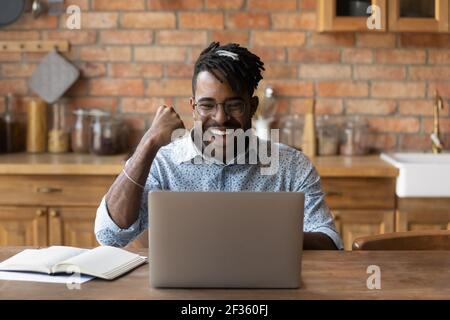 Excited black guy student seeing good exam result on laptop Stock Photo