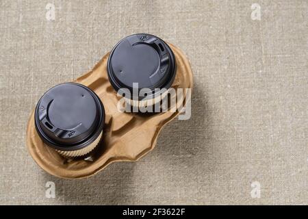Two disposable paper coffee cups with lids in a cardboard holder. Takeaway drinks Stock Photo
