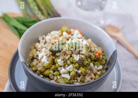 healthy barley soup with spring vegetables, asparagus, wild garlic and carrots Stock Photo