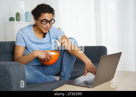Cheerful african american woman watching streaming netflix