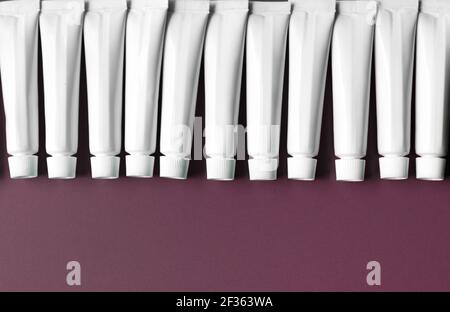 Container of white tubes on dark background with copy space, concept graphic resource Stock Photo
