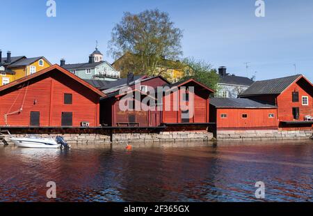 Rural Finnish landscape. Traditional old red wooden houses and barns are on the river coast, historical part of Porvoo town, Finland Stock Photo