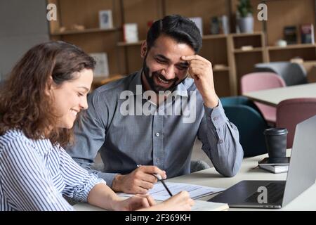 Two happy friendly diverse professional employees having discussion at work. Stock Photo