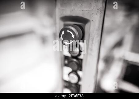 Shallow depth of field (selective focus) image with an emergency stop button on a control panel from a factory. Stock Photo