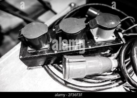 Shallow depth of field (selective focus) image with industrial and multiphase electrical plugs and sockets. Stock Photo