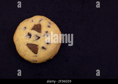 Homemade delicious single American chip cookies with chocolate drops, Isolated in black background. Copy space. Sweet Food Concept. Stock Photo