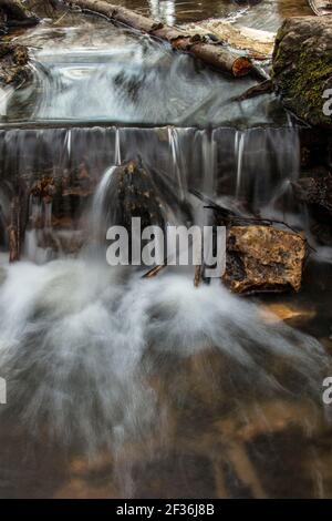 Moody intimate landscape of rushing water fall over and around rock Moody intimate landscape of rushing water fall over and around rock