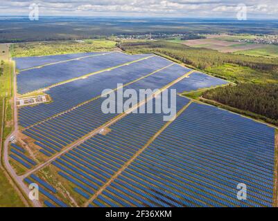 Solar panel produces green, environmentaly friendly energy from the setting sun. Aerial view from drone. Landscape picture of a solar plant that is lo Stock Photo