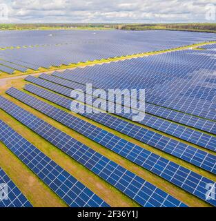 Solar panel produces green, environmentaly friendly energy from the setting sun. Aerial view from drone. Landscape picture of a solar plant that is lo Stock Photo