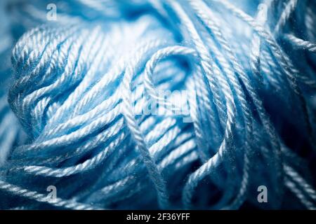 An extreme close-up with selective focus of blue and fuzzy bundled crochet threads. Stock Photo