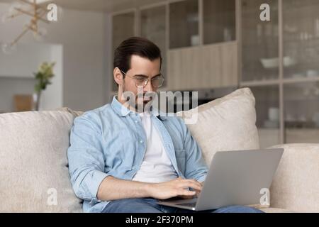 Young Caucasian man work on laptop at home Stock Photo