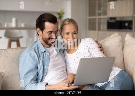 Smiling young couple relax together using laptop Stock Photo
