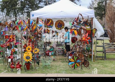 April 13 2018 Tulsa USA Tent booth at spring garden fair with all kinds of brightly colored yard ornaments on display and woman shopping