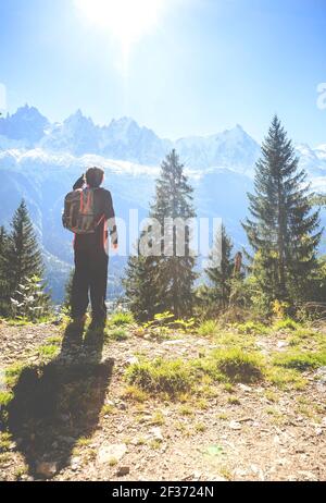 A young woman is hiking in the mountains near a ski resort town of Chamonix in France Stock Photo