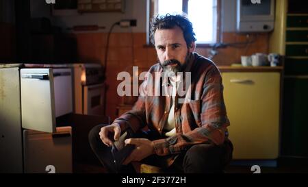Portrait of poor mature man with empty wallet indoors at home, poverty concept. Stock Photo