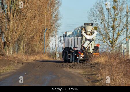 the driver washes the truck with a concrete mixer after work Stock Photo