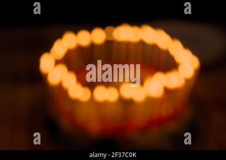 Closeup of defocused birthday cake with burning candles with dark background Stock Photo