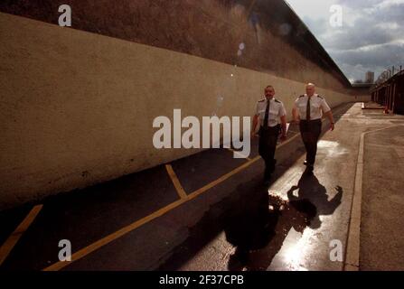 Winson Green Prison, Birmingham March 2001two prison guards walk along the perimeter wall Stock Photo