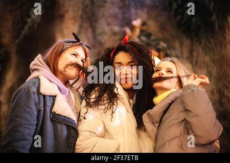 Female friends being silly making funny faces with hair mustaches Stock Photo