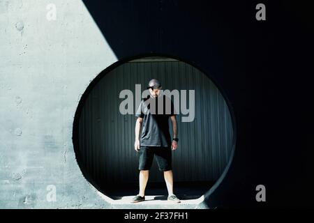 Stylish fashionable young guy in black clothes in an urban environment Stock Photo