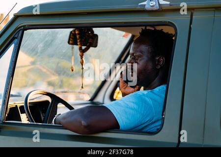 black african american man talking on the phone in his  camper van Stock Photo